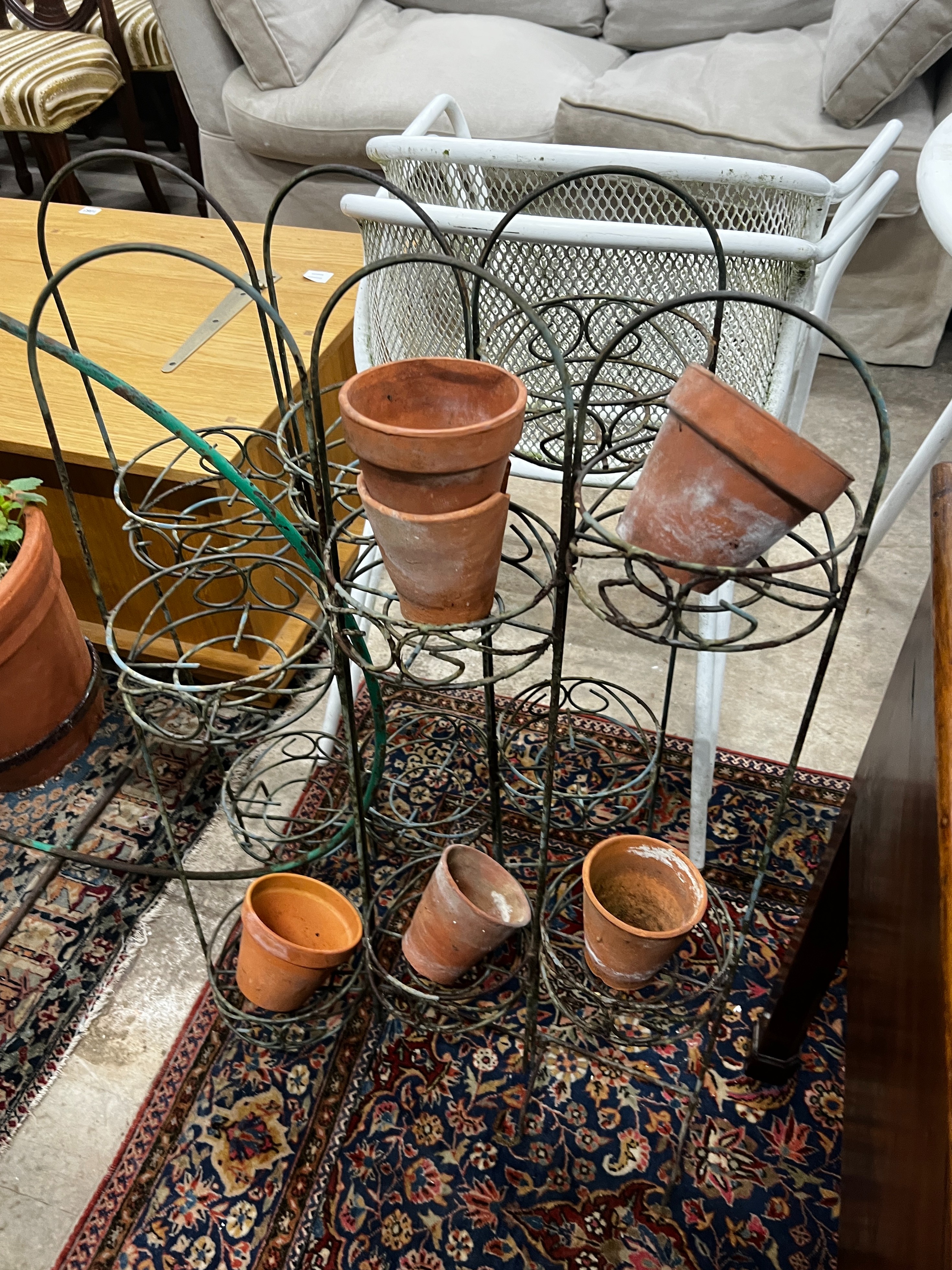 A wrought iron bicycle pot stand, height 98cm together with a pair of folding wirework pot stands